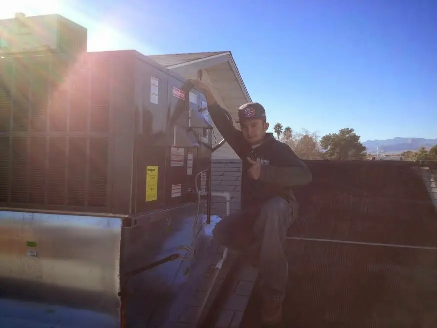 HVAC technician performing AC Tune-Up on a rooftop unit in Acushnet